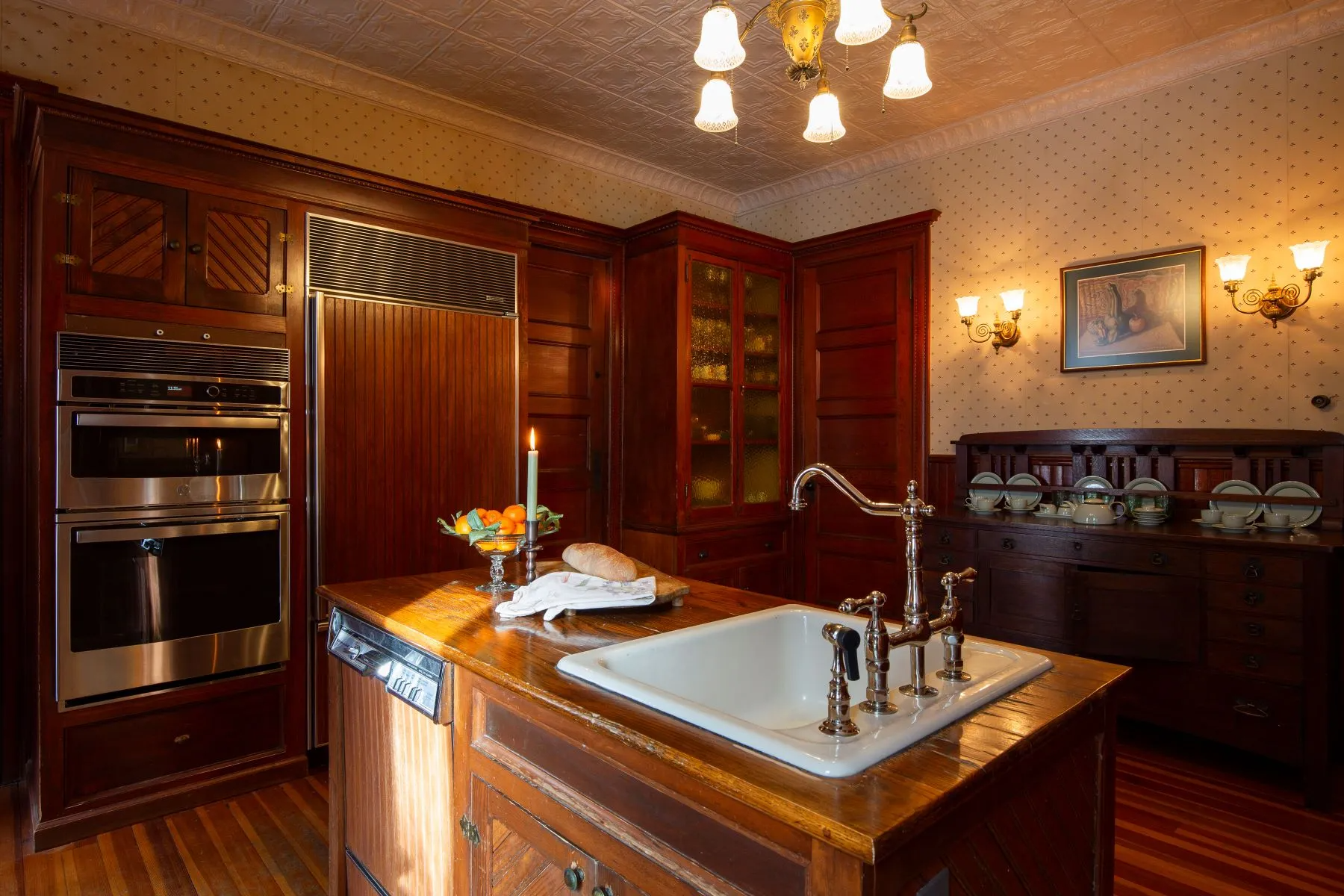 kitchen with wainscoting, wood-topped island, tin ceiling
