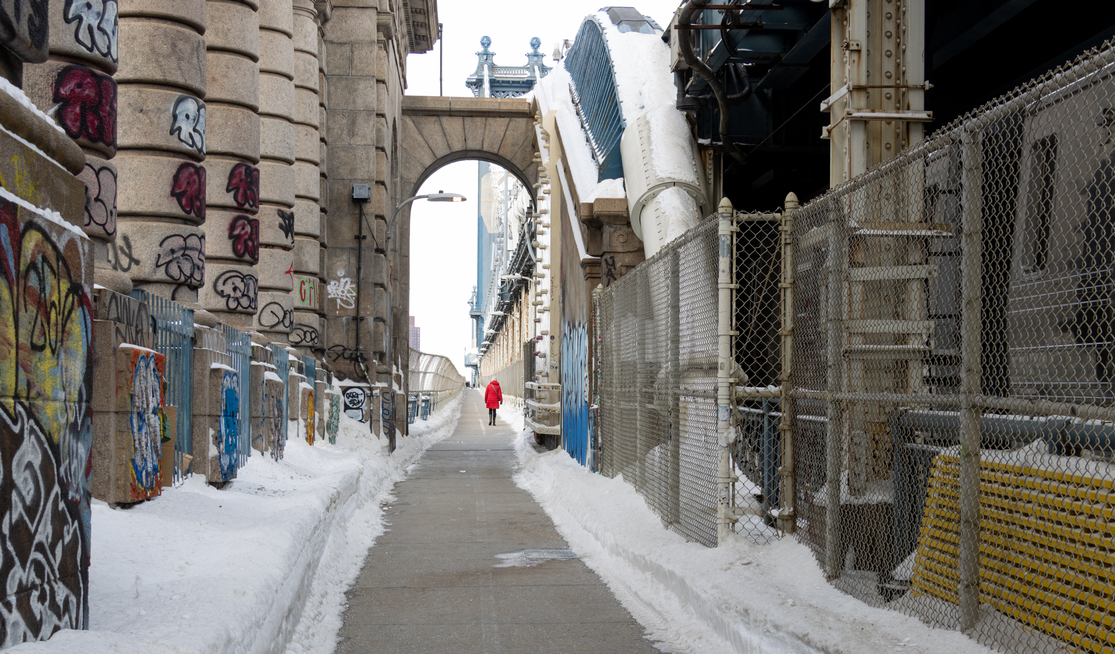 person in red coat walking on the bridge