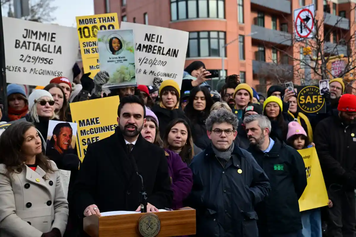 mayor at podium with crowd with signs