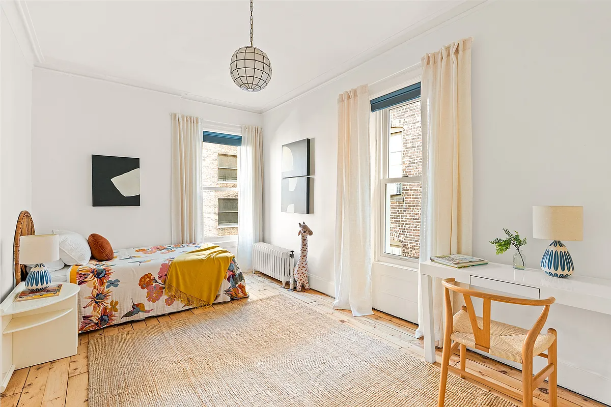 bedroom with wide planked floor boar set up as a childs room