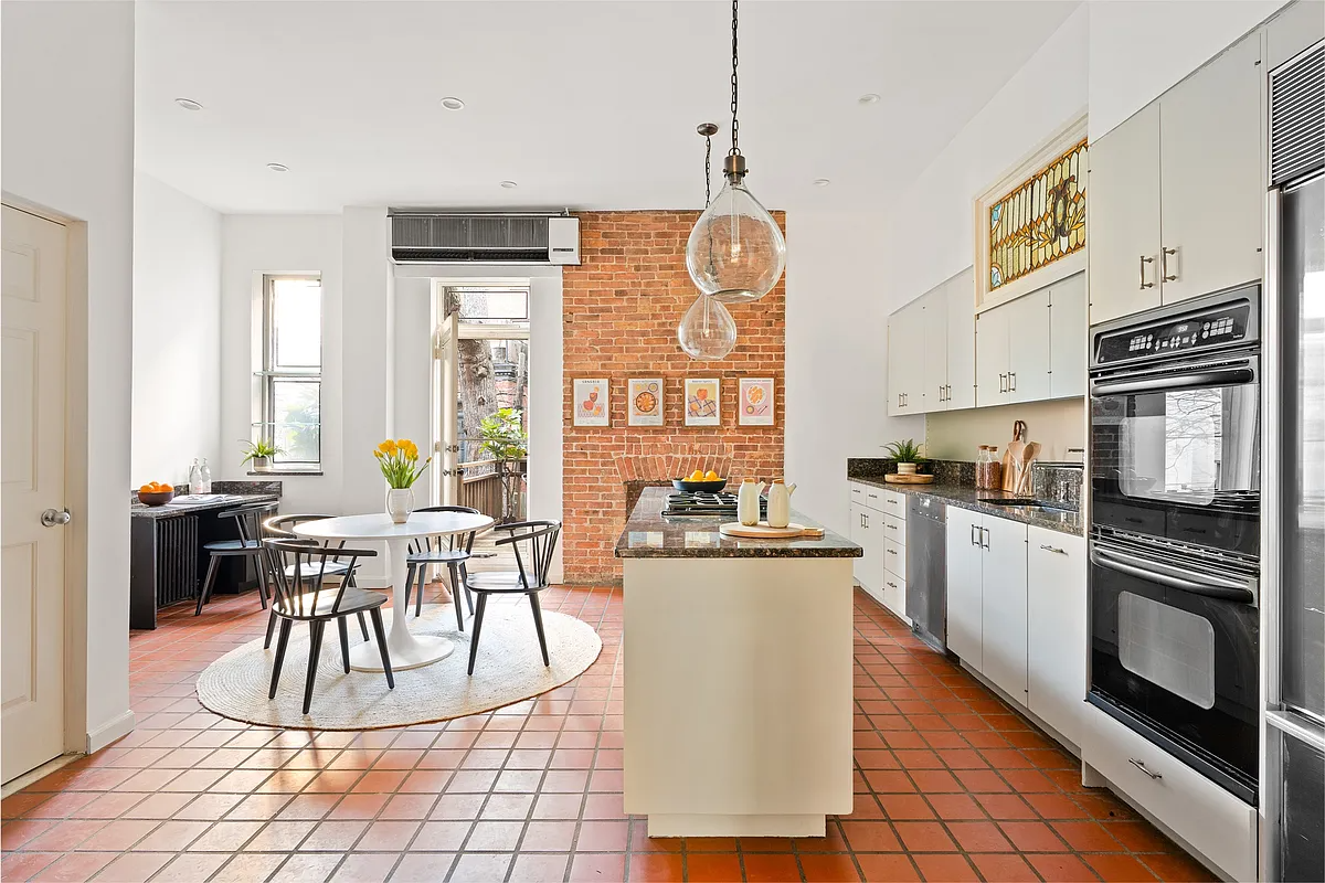 kitchen with terra cotta tile floor, cream cabinets and room for a table
