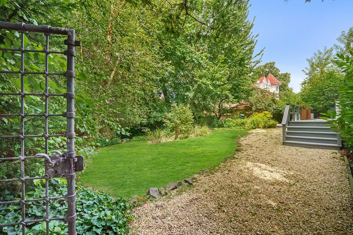 rear yard with gravel path, lawn with plantings