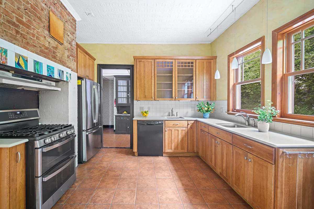 windowed kitchen with wood cabinets, tile floor