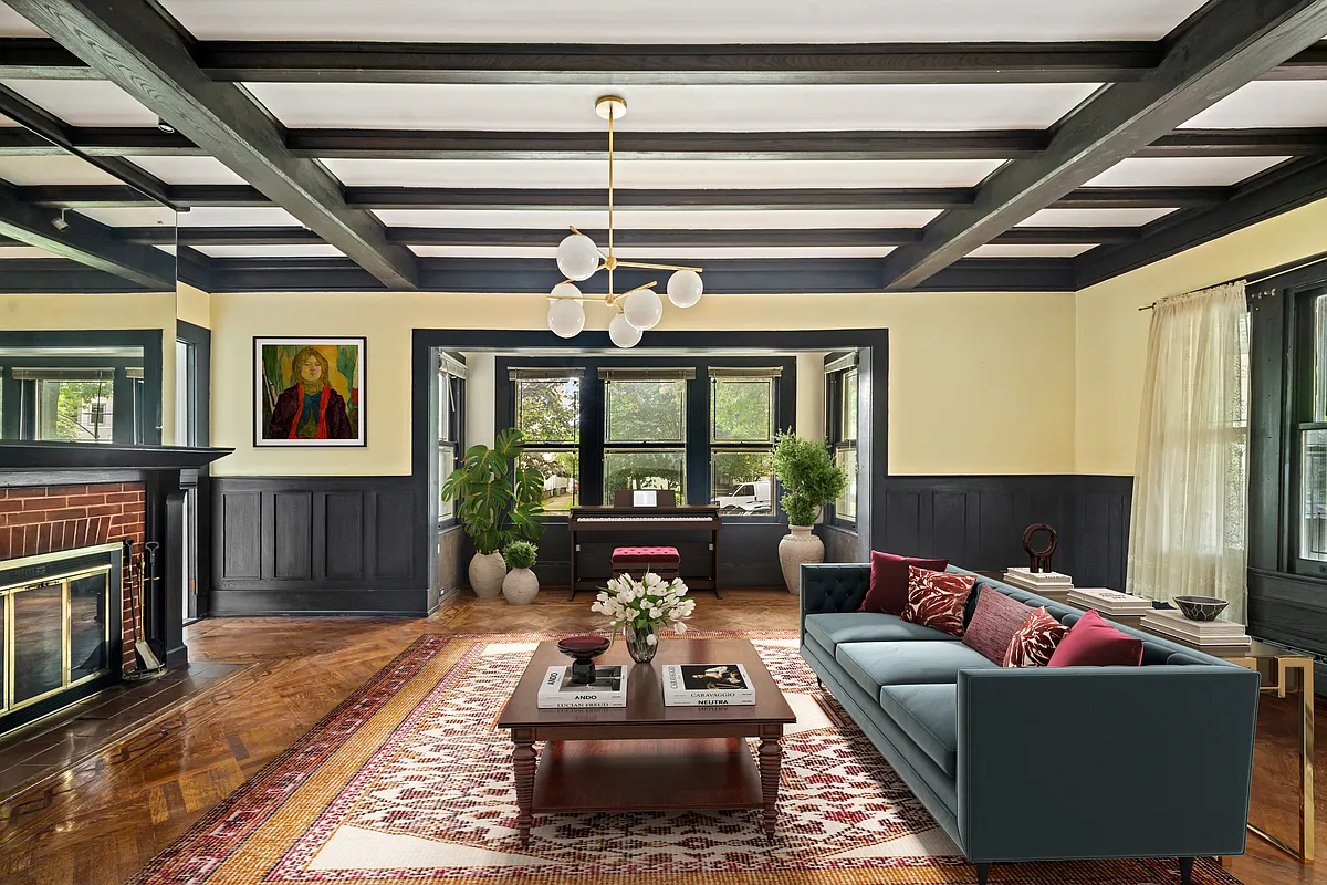 virtually staged parlor with beamed ceiling and brick fireplace