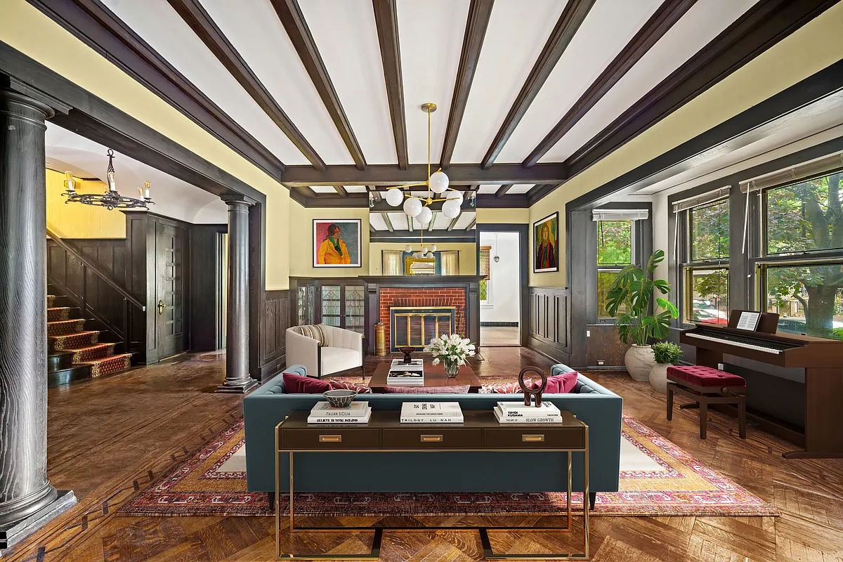 virtually staged parlor with beamed ceiling and brick fireplace