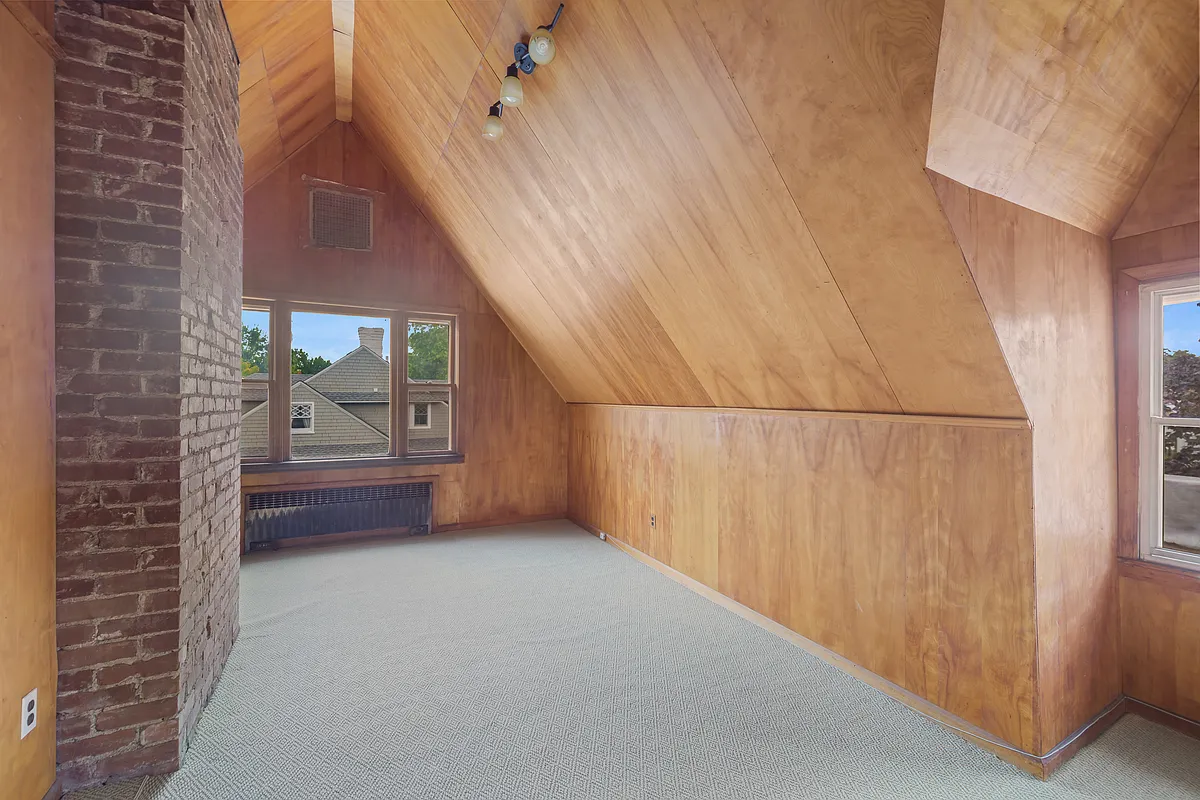 top floor room with paneled walls and ceiling, carpet