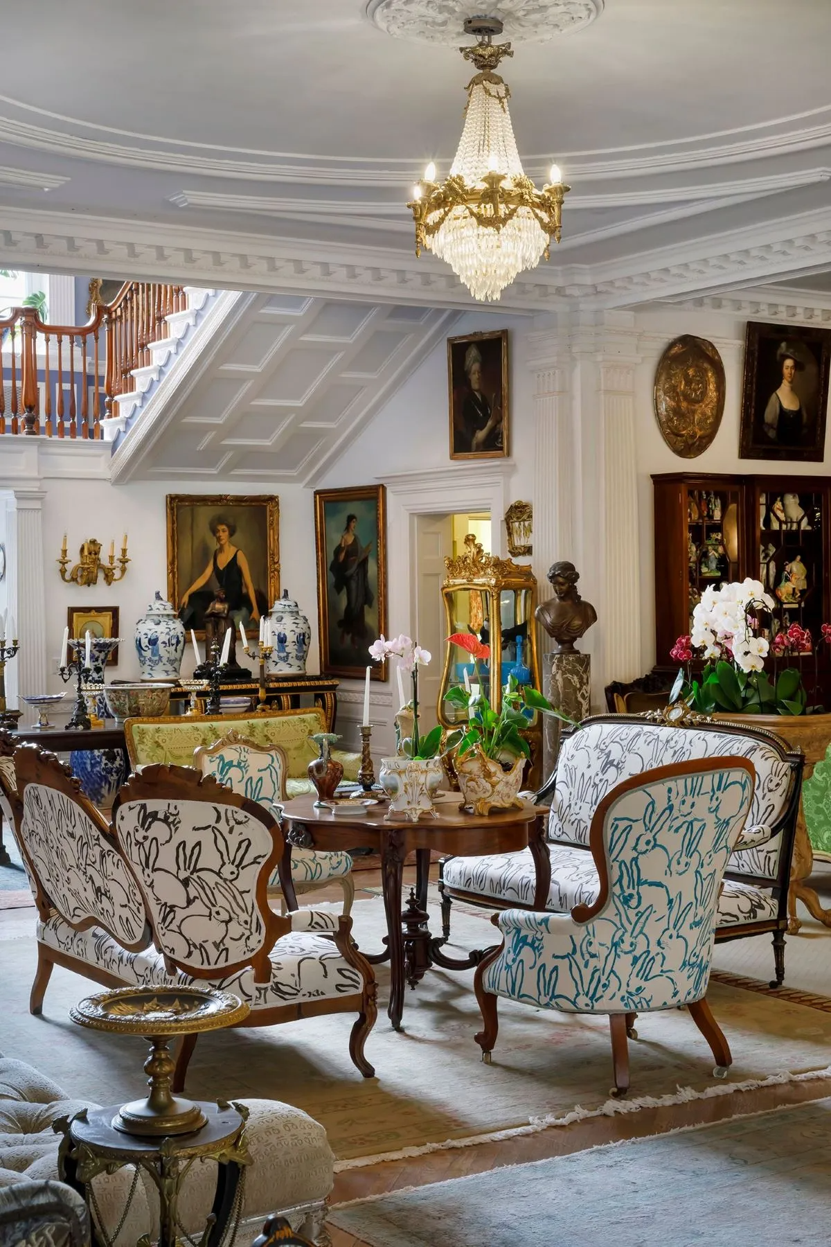 grand entry hall with multiple seating areas, plasterwork, wood floor