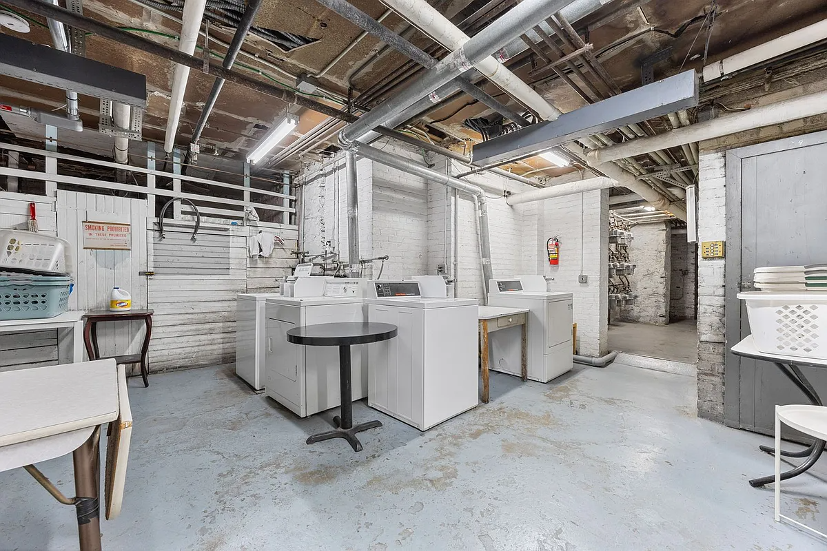 laundry room in building with two washers and two dryers visible