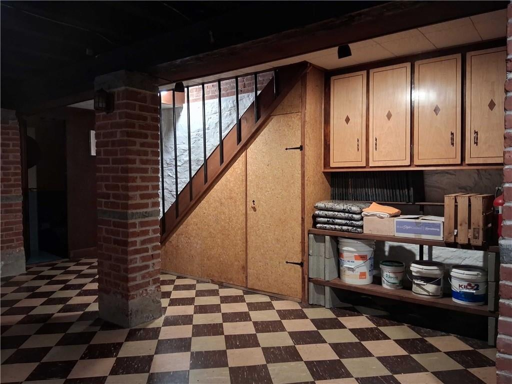 basement rumpus room with rubble stone walls and tile floor