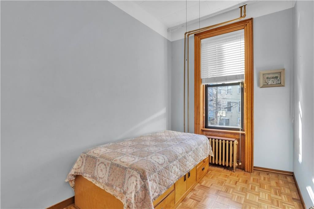 narrow bedroom with parquet floor