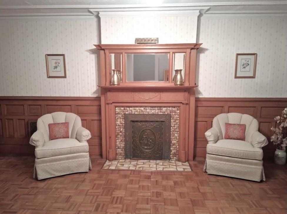 garden level dining room with wainscoting wallpaper, mantel