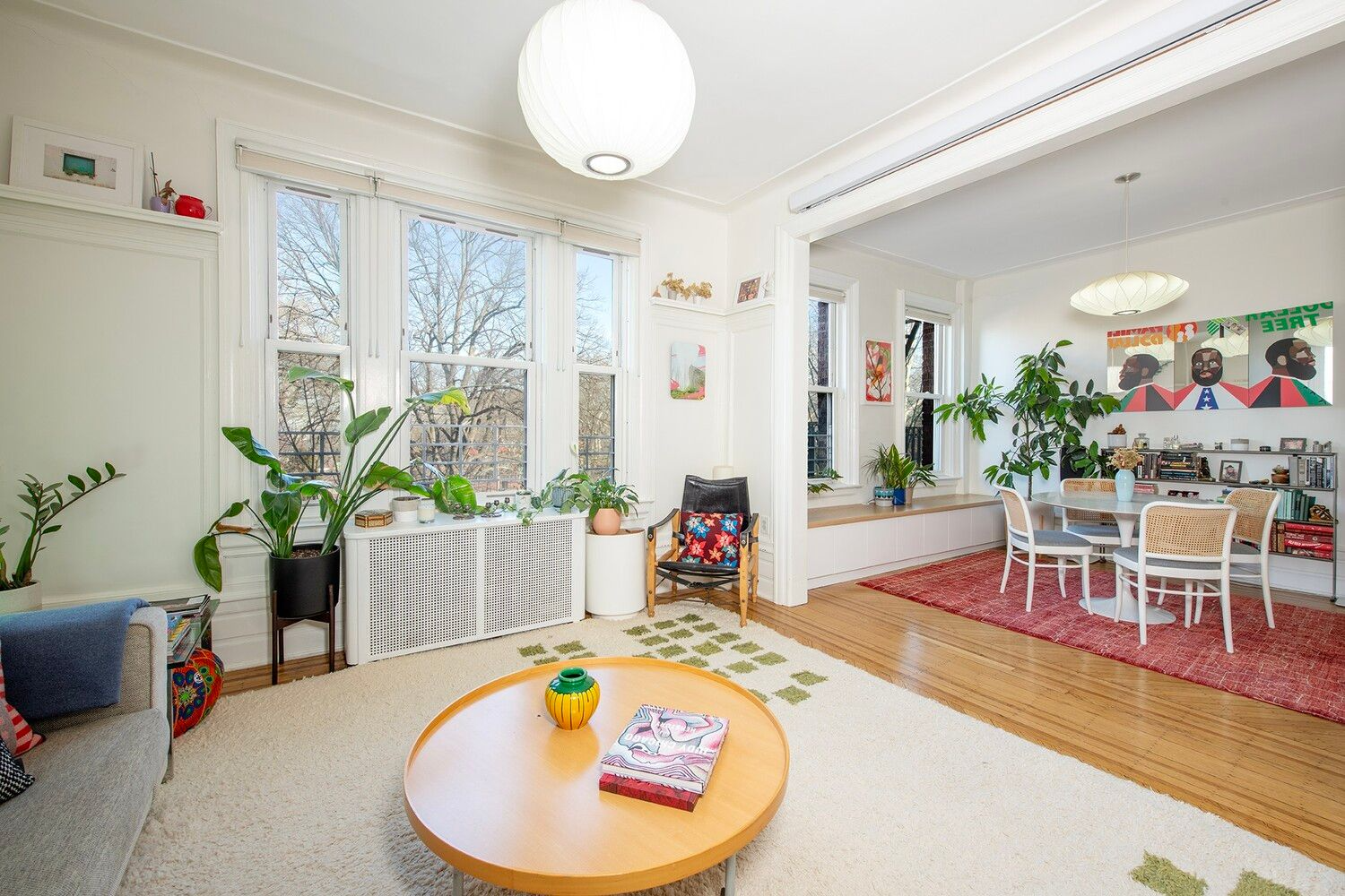living room with wood floor, large doorway into dining room