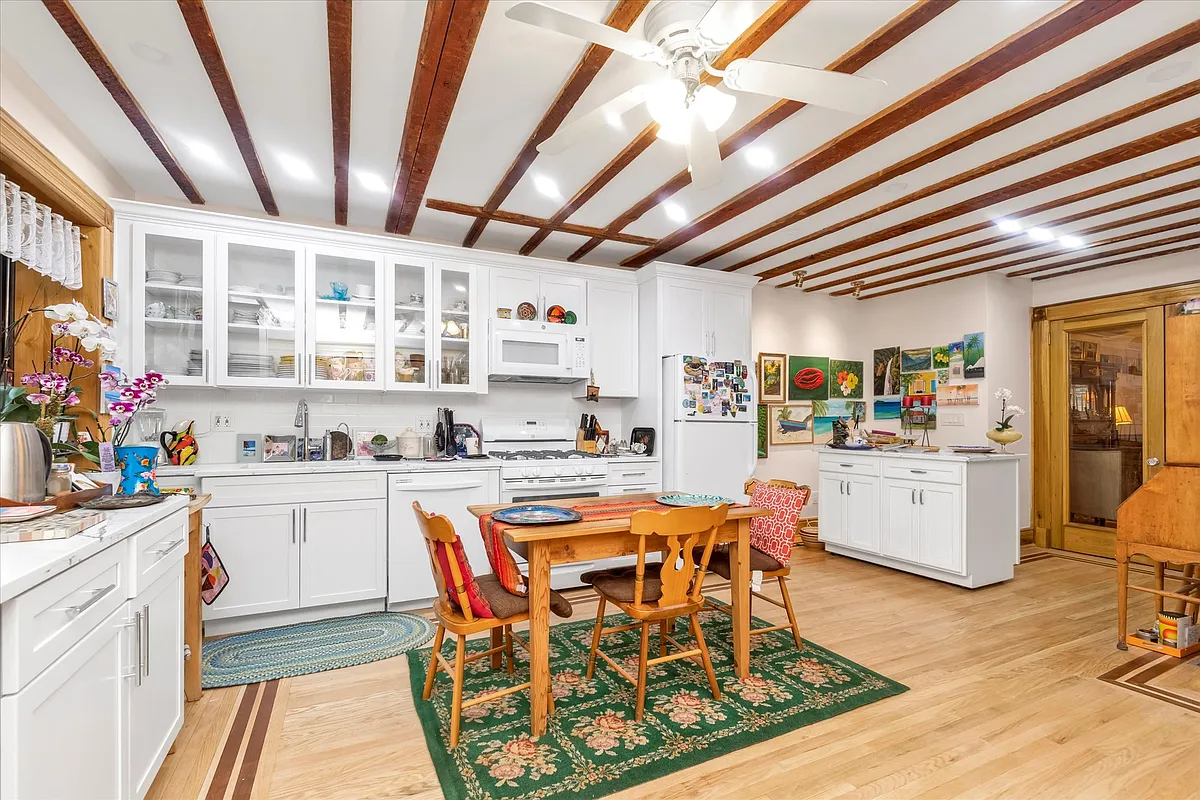 eat-in kitchen with wood floor, white cabinets