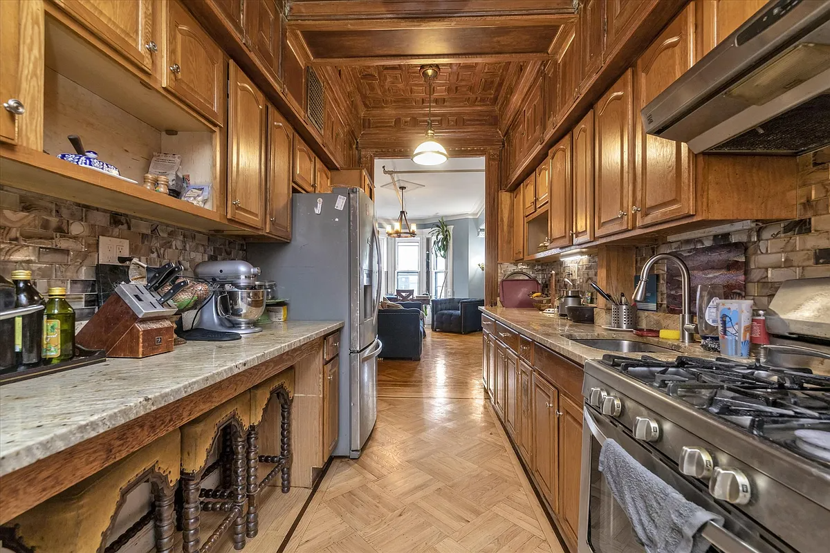 upper duplex galley kitchen with wood cabinets
