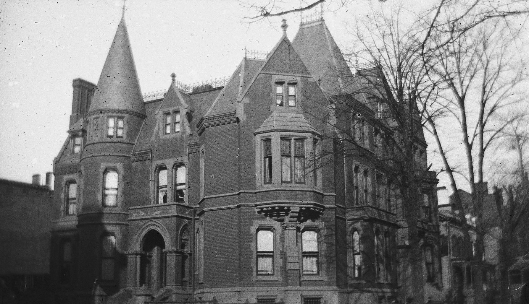 black and white photo of a mansion on a corner