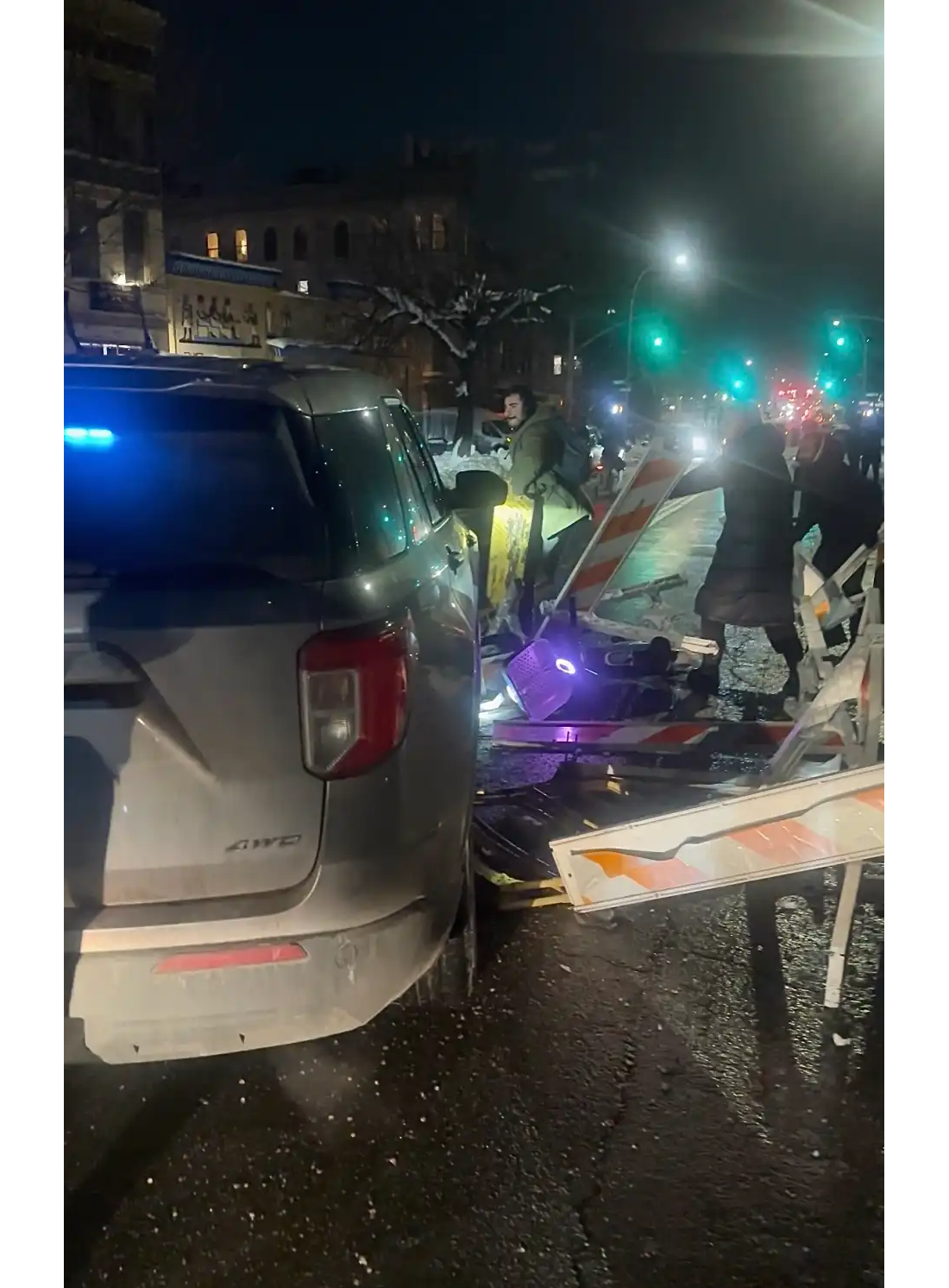 people blocking a car at night