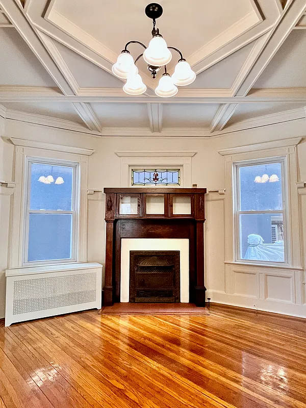 dining room with wood mantel, beamed ceiling
