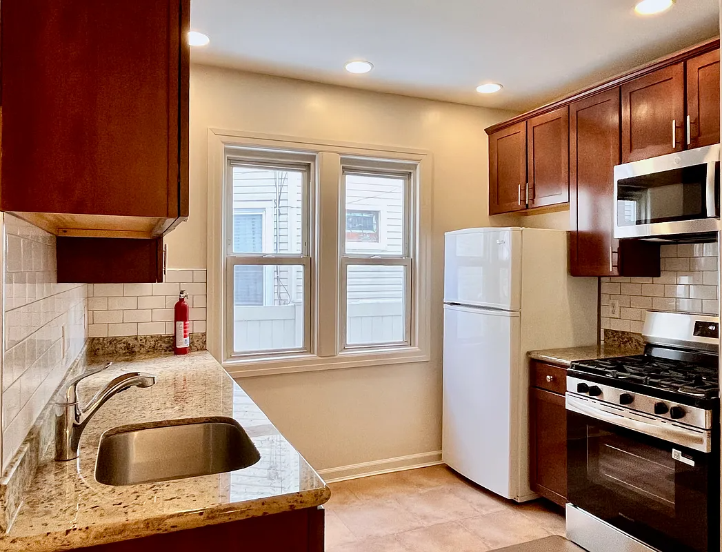 windowed kitchen with wood cabinets, white subway tile