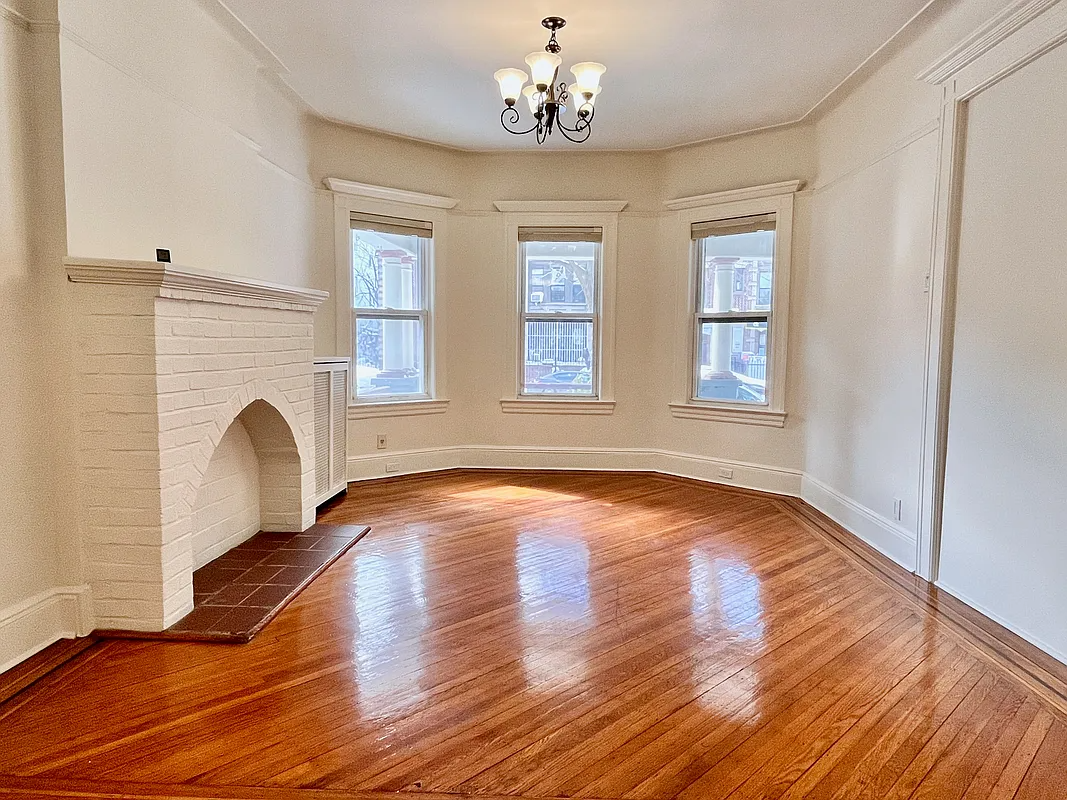 living room with brick mantel, wood floor