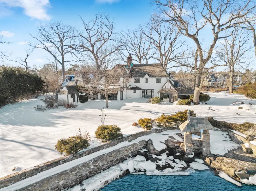 aerial view of the house and stone wall at waterfront
