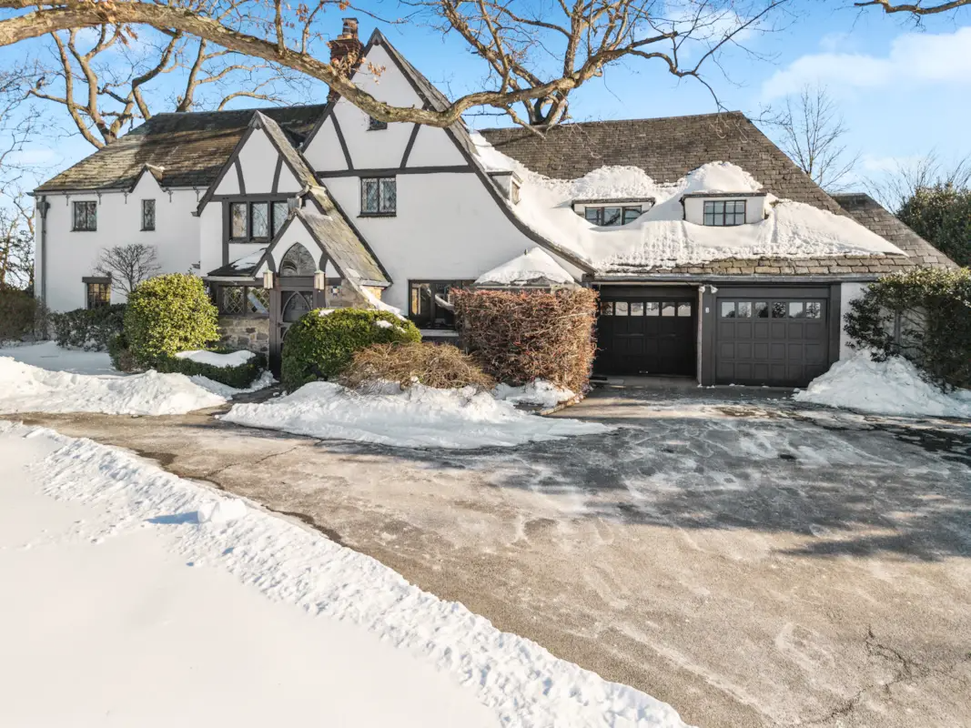 winter view of the driveway leading to the two car garage
