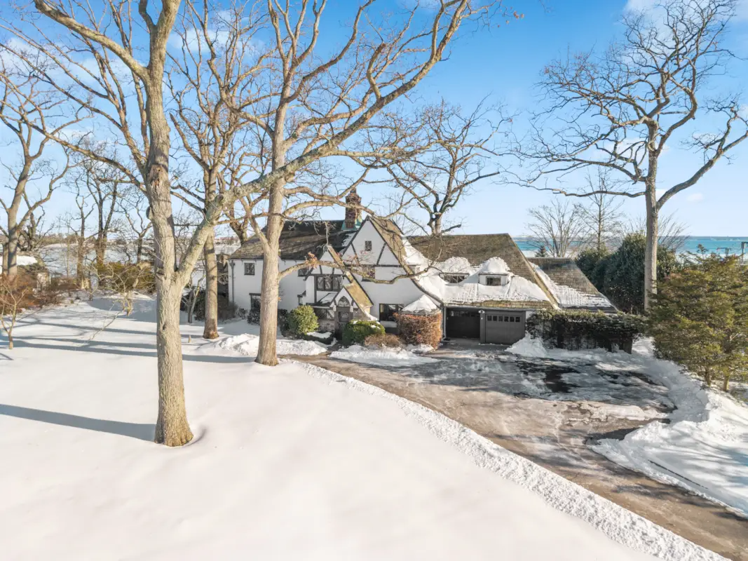 aerial view of the house in the winter with driveway and garage