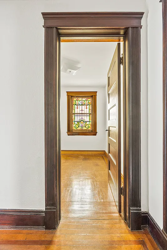 view from hall to a stained glass window in a room