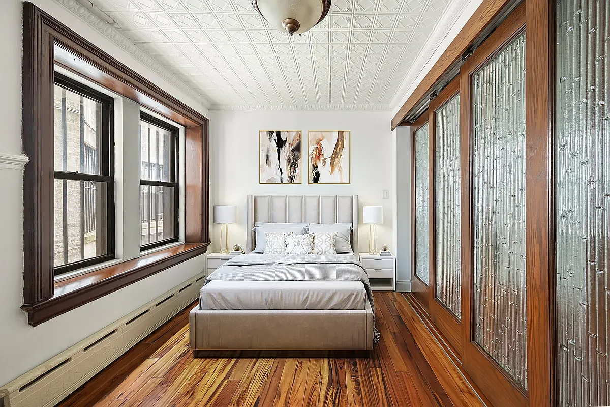 a second bedroom with sliding glass doors and a tin ceiling