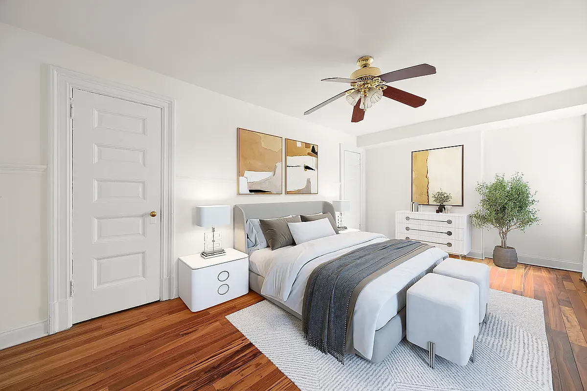 a bedroom with a wood floor and virtually staged with a bed and end tables