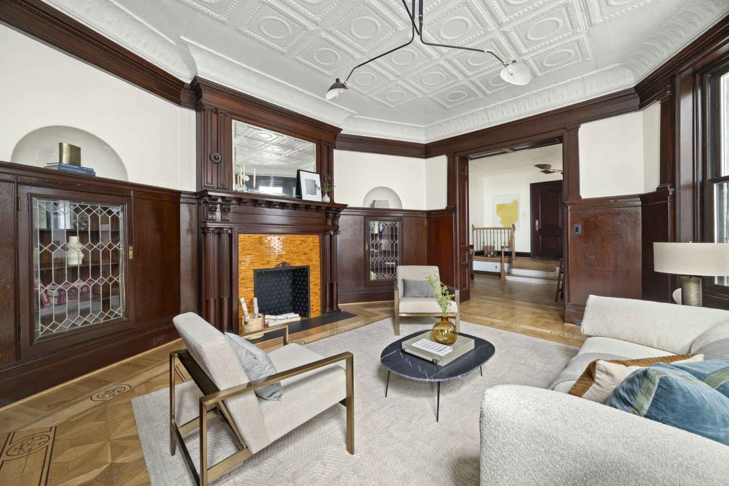 living room with built-ins, mantel, tin ceiling