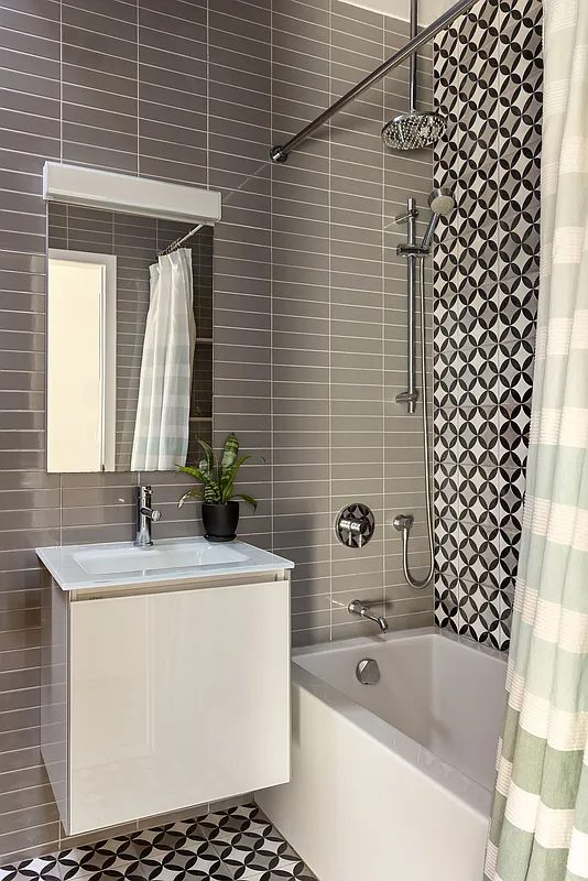 bathroom with white floating vanity and a tub