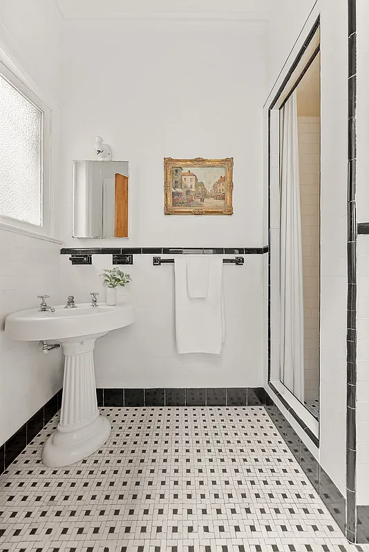 bathroom with built-in shower, white and black tile