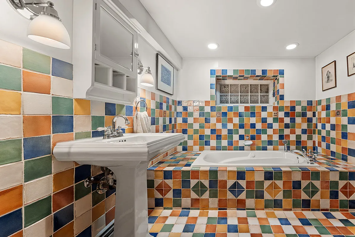bathroom with multi-colored tile on walls and surrounding tub