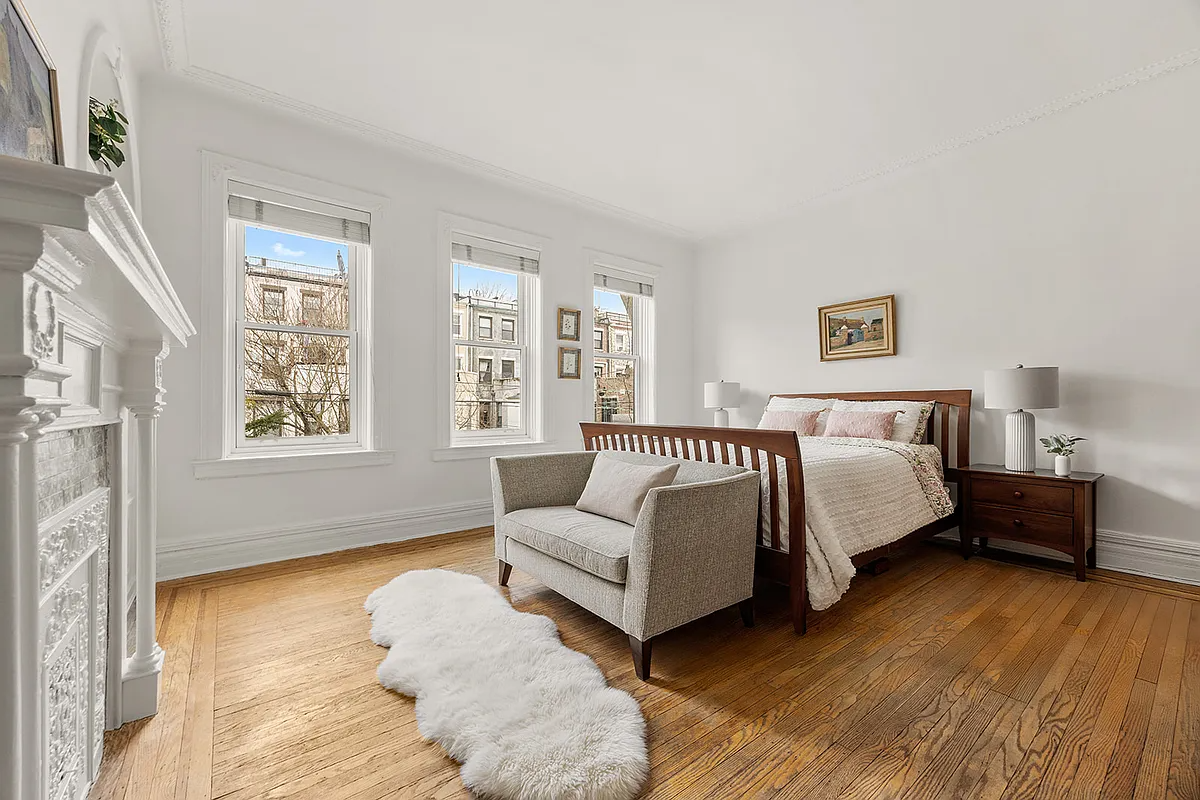 bedroom with white walls, wood floor