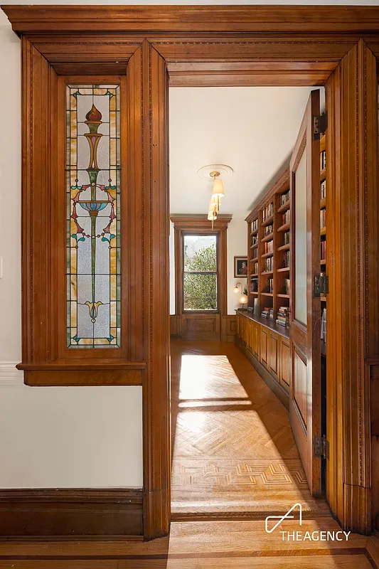 view from hall into living room with built-in bookshelves