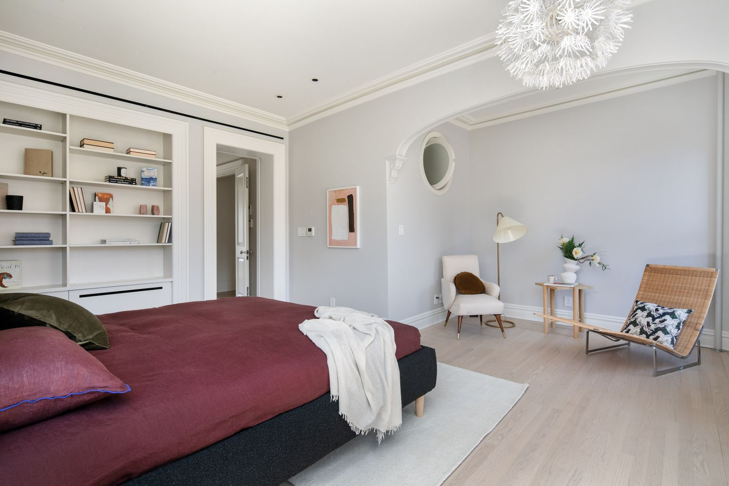 bedroom with arched niche, pale wood floors