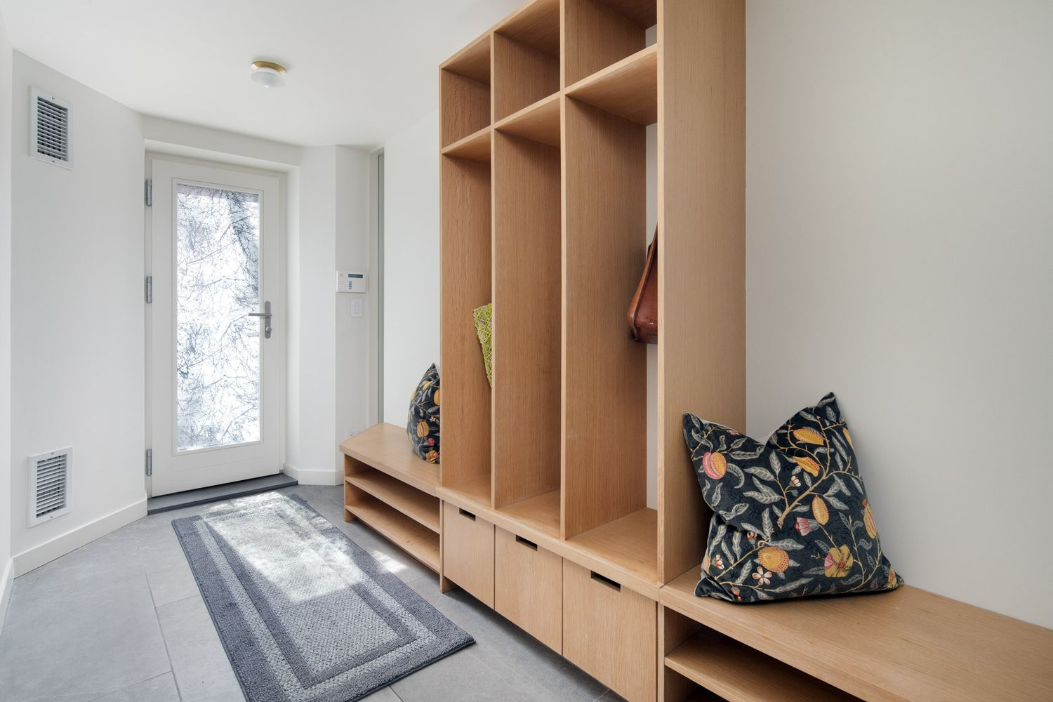 garden level mudroom with tile floor and built-in storage