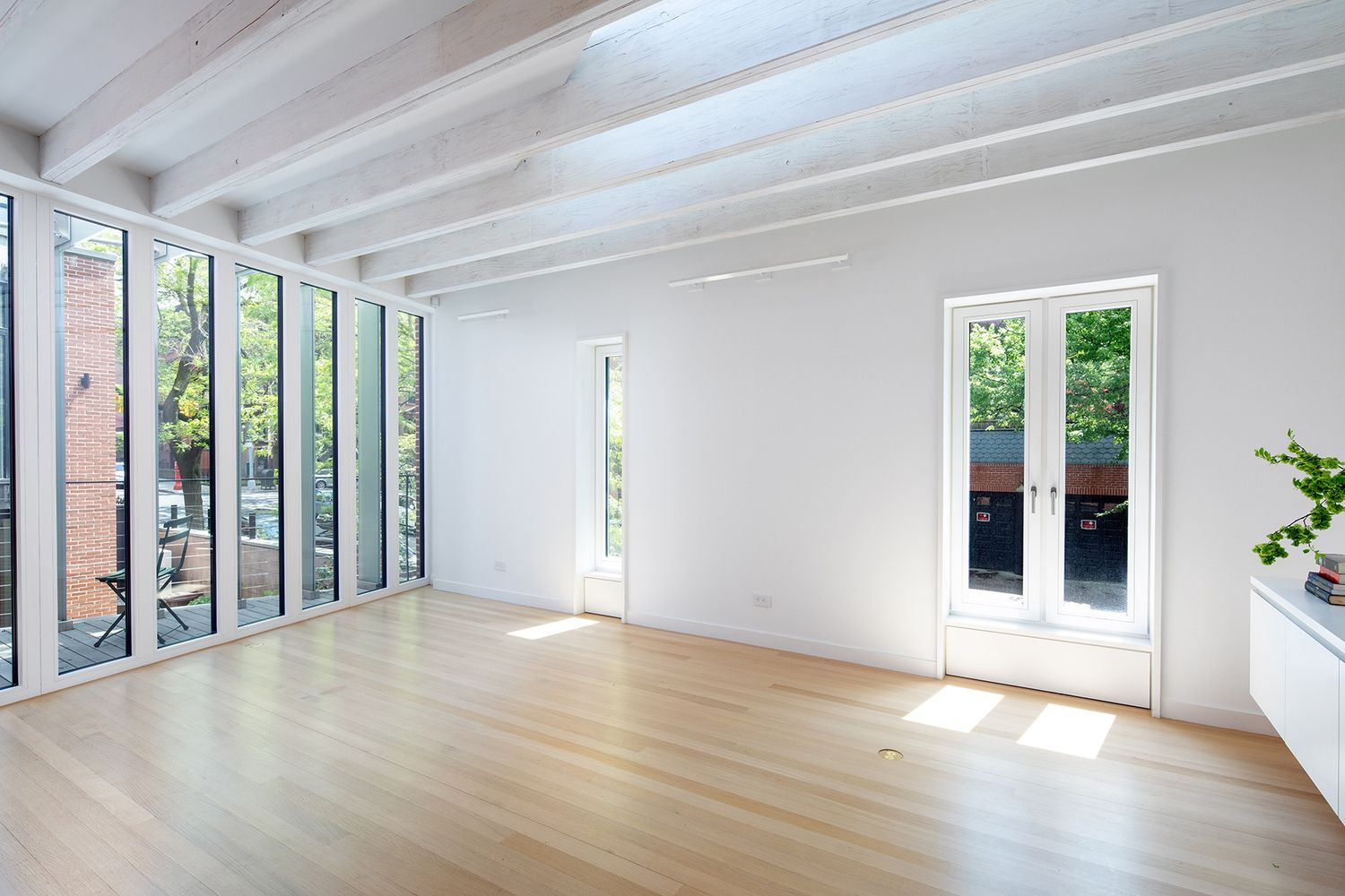 office space above the garage with white walls and a wall of glass