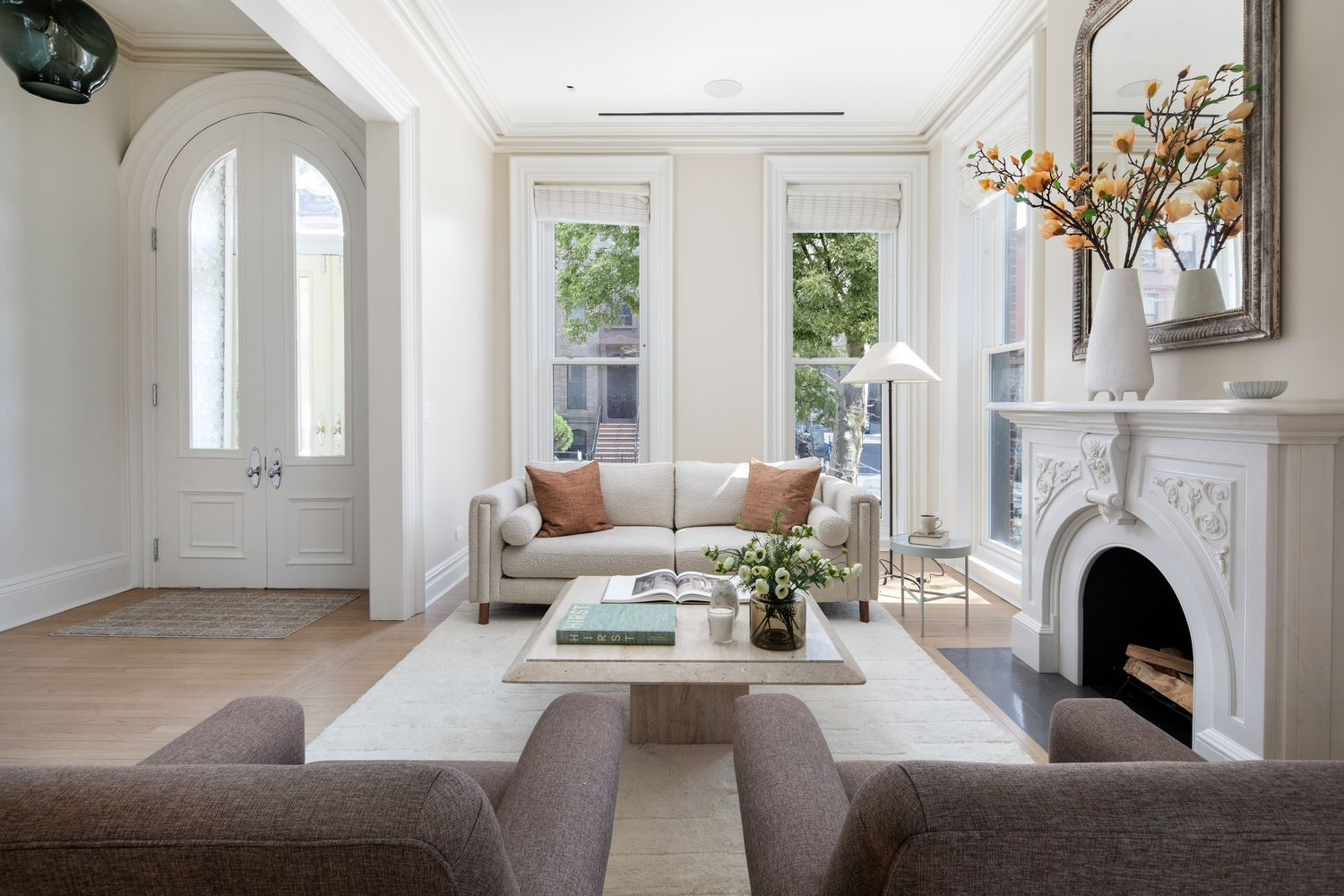 parlor with cream walls, moldings, two exposures, a mantel