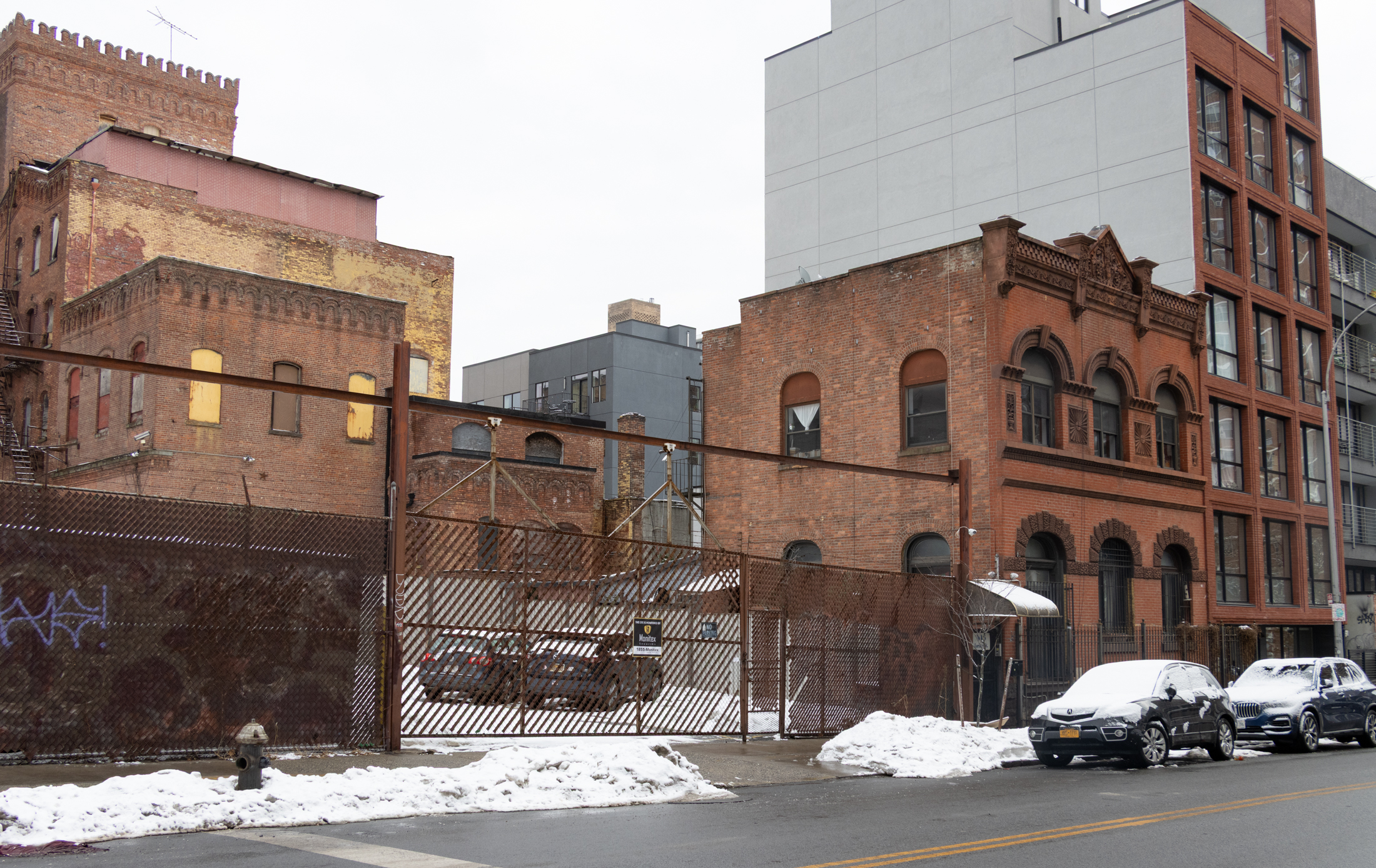 parking lot and a brick office with arched windows