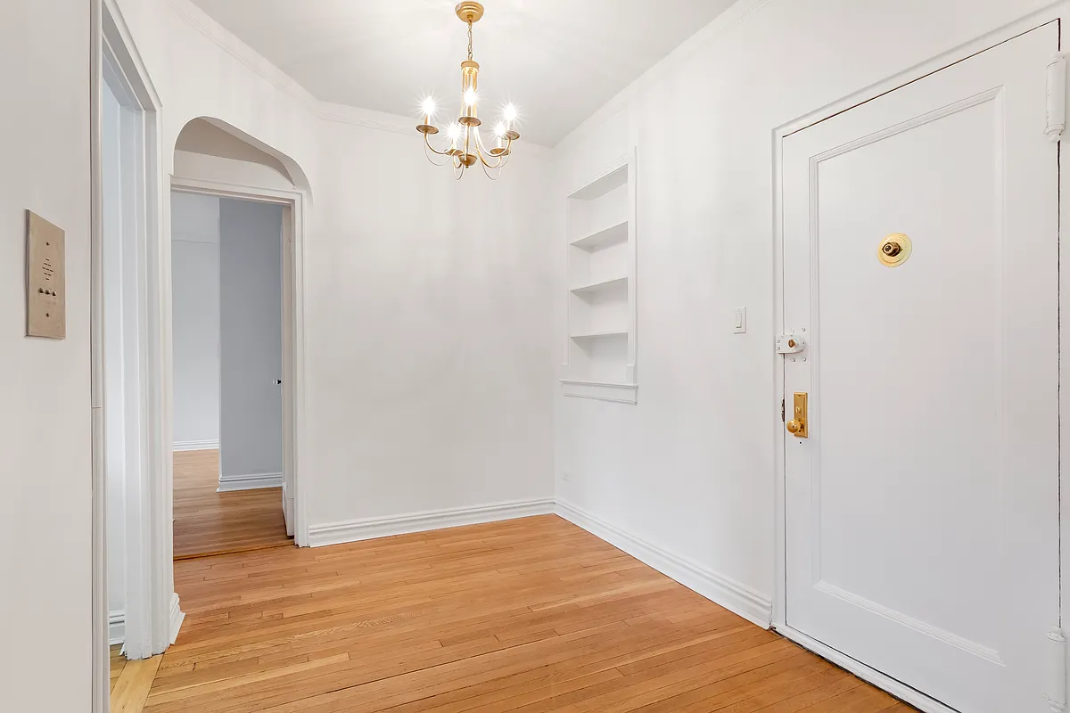 foyer with arched doorway, niche with shelves