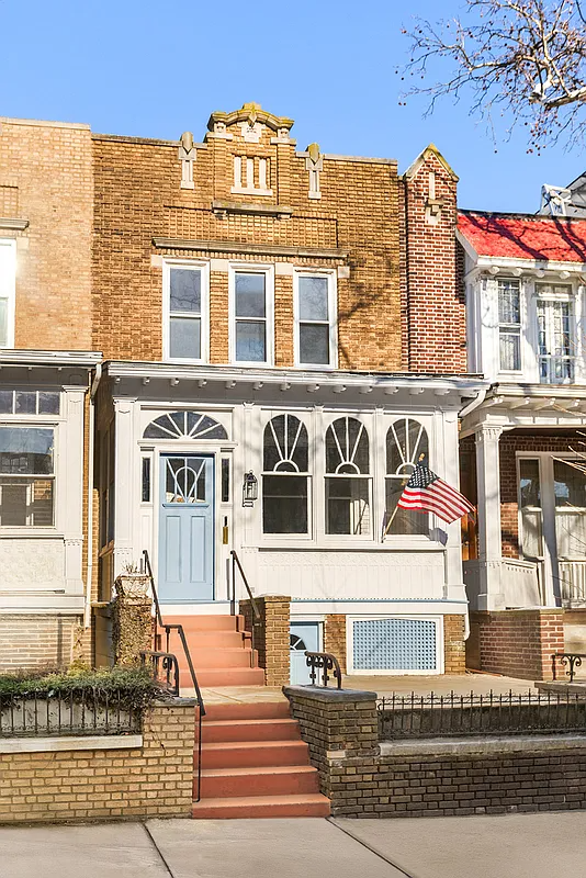 exterior of a brick rowhouse with an enclosed front porch