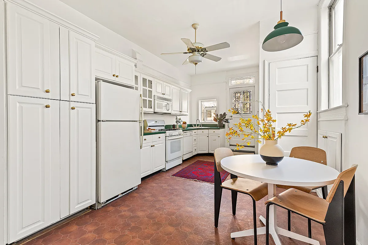kitchen with tile floor, white cabinets, door to rear yard
