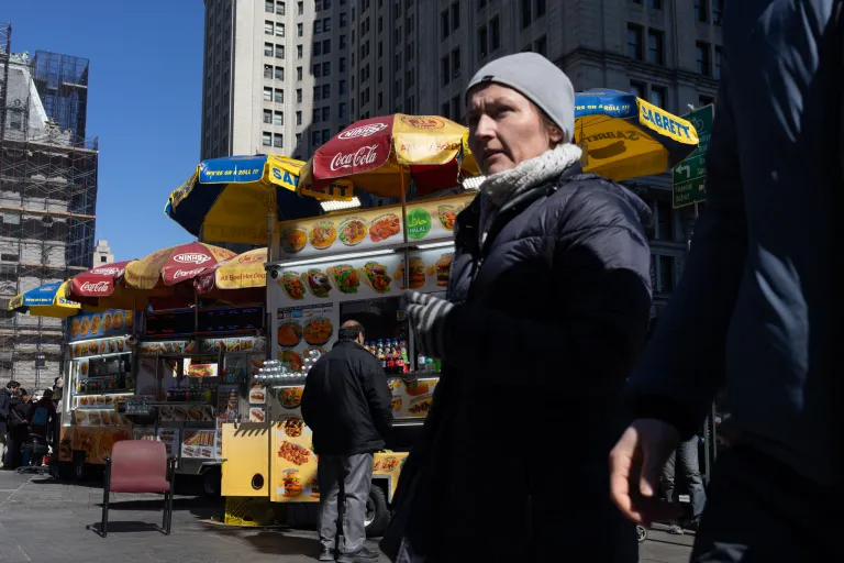 Halal cart vendors serve tourists and workers near City Hall, March 18, 2026.