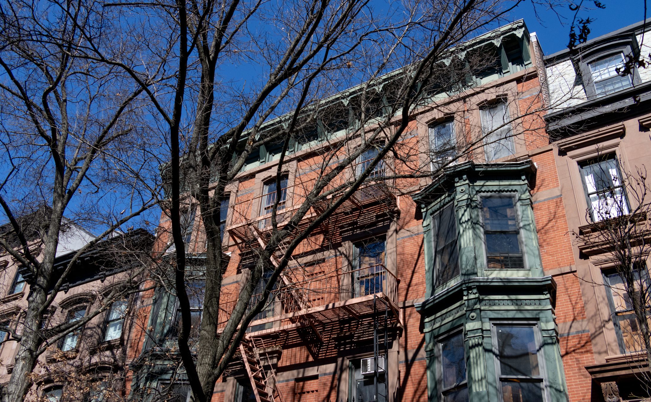 a brick house with green oriel windows