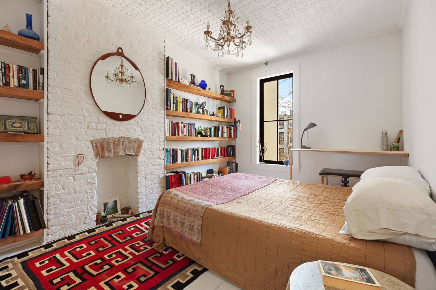 bedroom with white painted brick, tin ceiling
