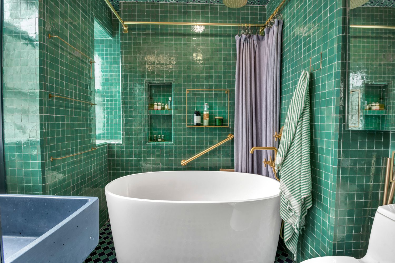 bathroom with large soaking tub, green tiles on the walls and green and blue tiles on floor and ceiling
