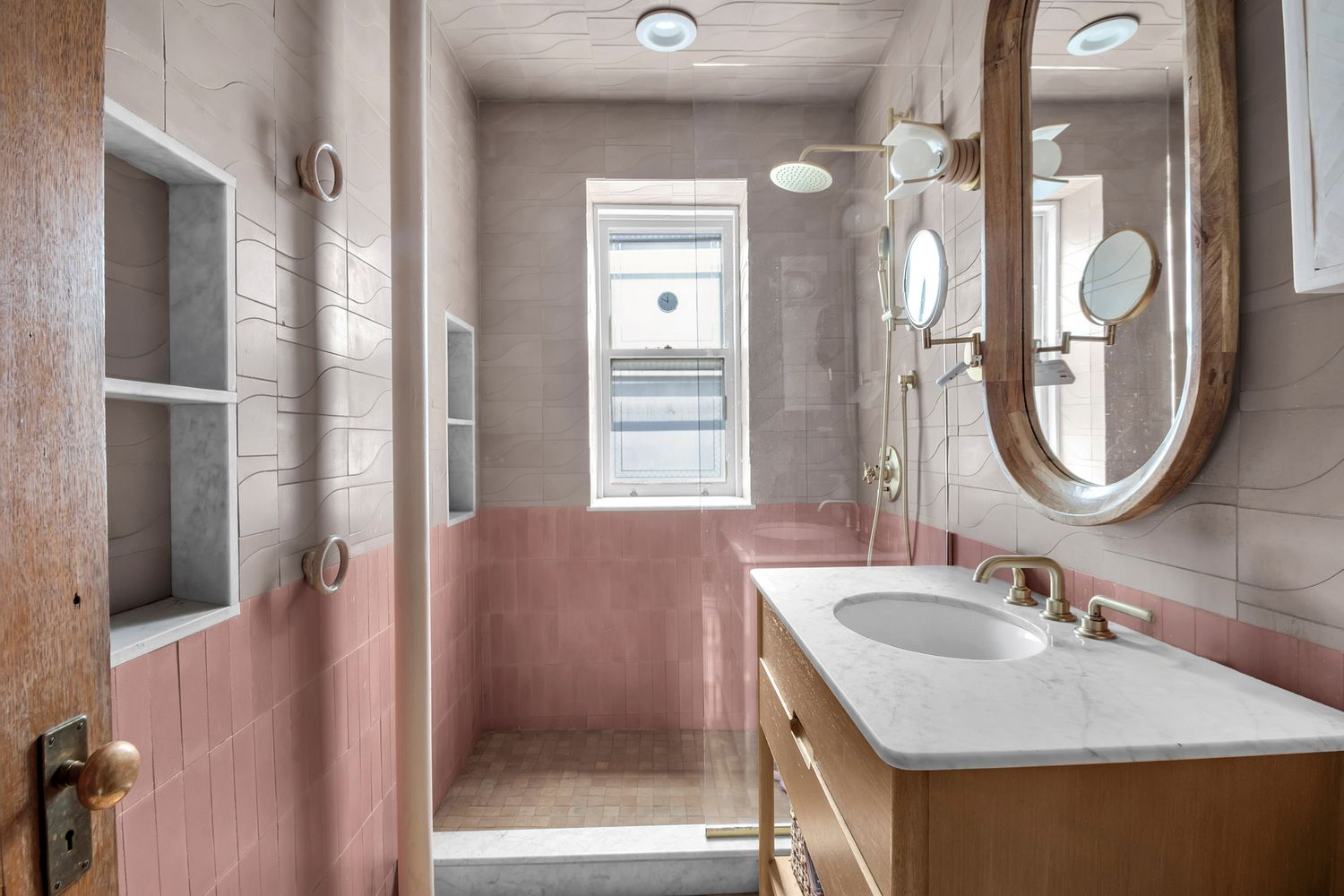 bathroom with walk-in shower, pink and beige tiles, wood vanity