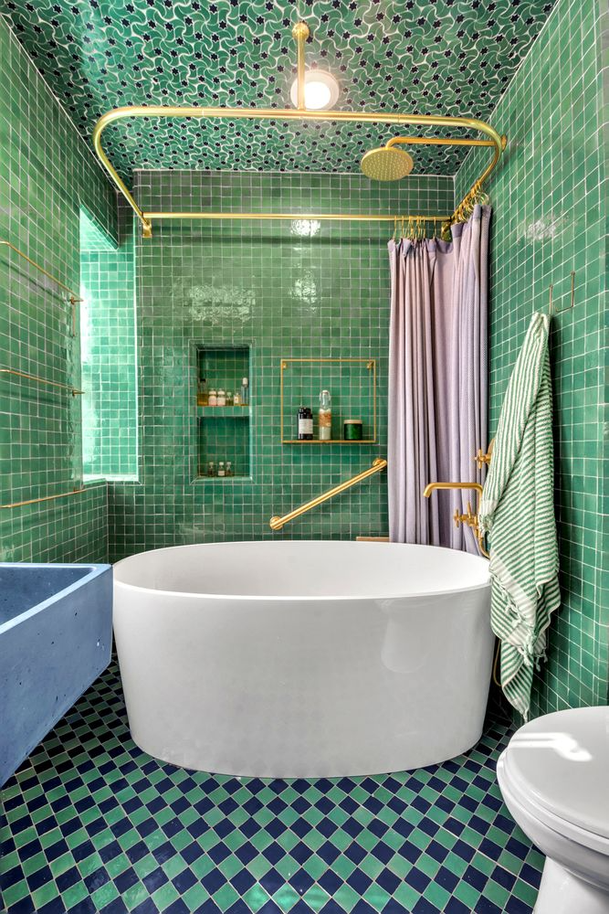 bathroom with large soaking tub, green tiles on the walls and green and blue tiles on floor and ceiling