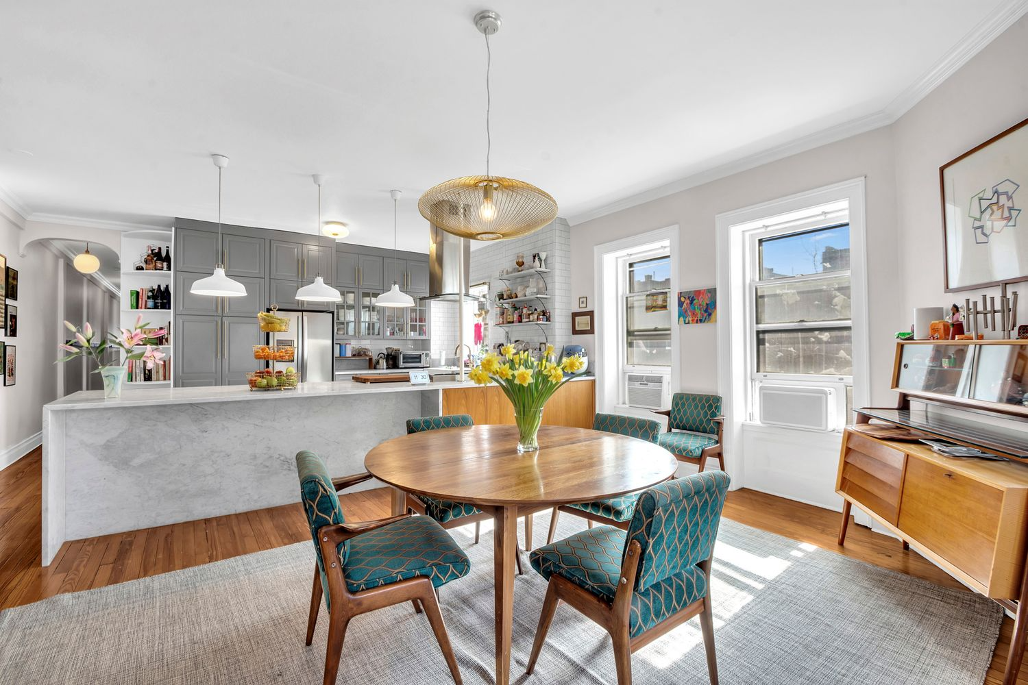 open plan kitchen and dining room with a wood floor, gray cabinets